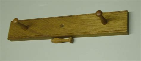 A Wooden Coat Rack With Two Pegs On It