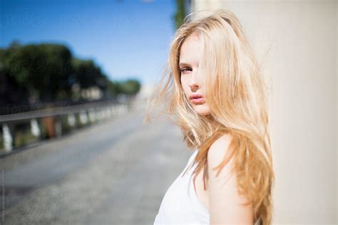 candid blonde girl leaning against the wall by stocksy contributor michela ravasio stocksy
