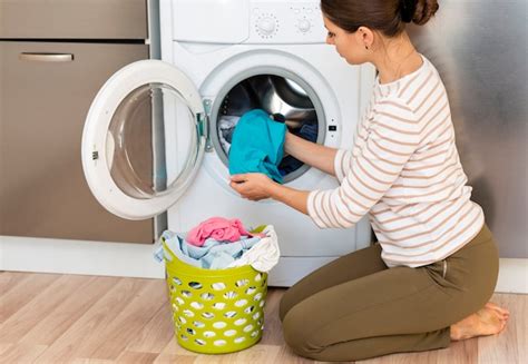 Mulher tirando a roupa na máquina de lavar roupa Foto Premium