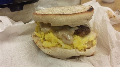 A Sausage And Egg Sandwich Sitting On Top Of White Paper