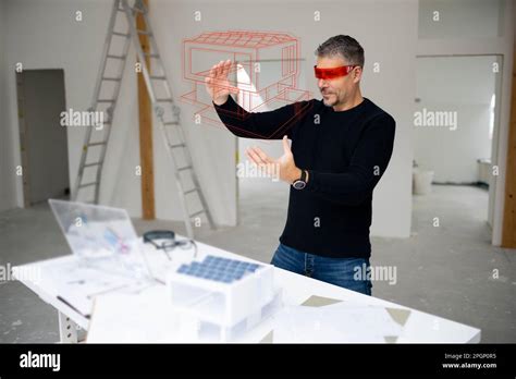 Architect Wearing Virtual Reality Simulator Examining House Model And