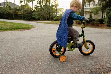 Caucasian Boy Riding Bicycle With Training Wheels Stock Photo Dissolve