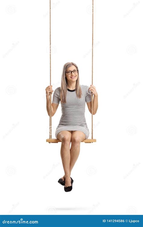 Young Cheerful Woman Sitting On A Swing And Smiling At The Camera Stock