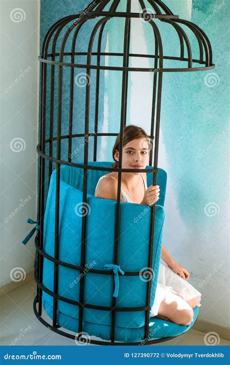 mental mind prisoner woman in cage home confinement freedom of cute girl in cage chair stock