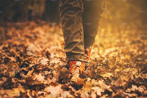 Feet sneakers walking on fall leaves | High-Quality People Images ...