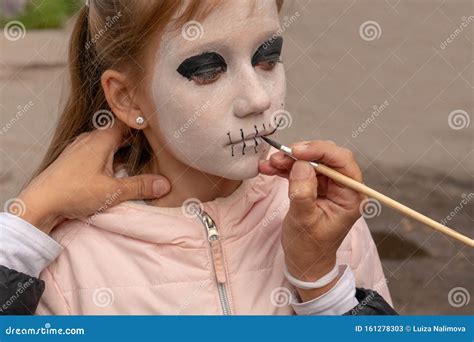 Mamma Dipinge La Faccia Di Figlia Per La Festa Di Halloween Nel Cortile