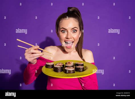 Close Up Portrait Of Attractive Hungry Cheerful Girl Eating Fresh Sushi Isolated Over Bright