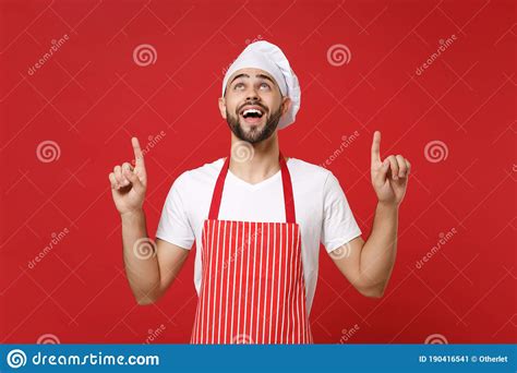 Amazed Young Bearded Male Chef Cook Baker Man In Striped Apron White T Shirt Toque Chefs Hat
