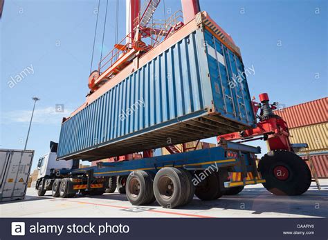 Crane Loading Cargo Container Onto Lorry At Commercial Dock Stock Photo