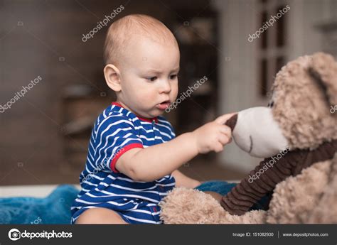 Boy Playing With Teddy Bear — Stock Photo © Lenamiloslavskaya 151082930