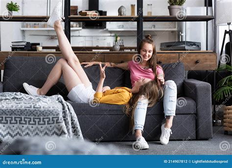 Two Smiling Lesbians On Sofa In Cozy Living Room Stock Photo Image