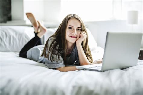 Teenage Girl Lying On Bed Using A Laptop Stock Image Image Of