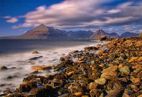 Landscape Photography Of Rock Near Body Of Water Under Nimbus Clouds