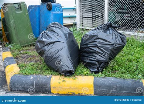 Black Plastic Trash Bin Bags Of Garbage On The Pavement Clean