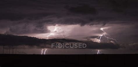 Two Cloud To Ground Lightning Bolts Shoot Through The Low Clouds Of A