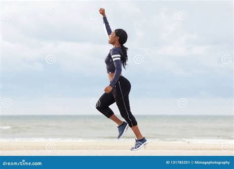 Full Body Young African American Woman Running With One Arm Raised At
