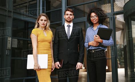 Portrait Of Three Business People Standing Together In Front Of Office