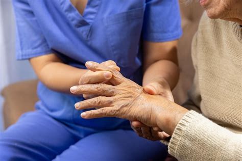 Premium Photo Caregiver Massaging Finger Of Elderly Woman In Painful Swollen Gout
