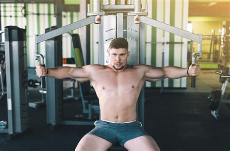 Premium Photo Muscular Man Working Out In Gym Doing Exercises At