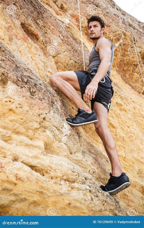 Young Man Climbing A Steep Wall In Mountain Stock Image Image Of
