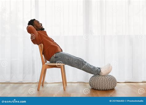 Relaxed African American Man Sitting In Chair At Home Stock Image