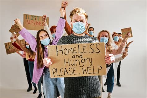 Female Holds Cardboard With Inscription That Homeless Are Hungry Asking For Help For Them Stock