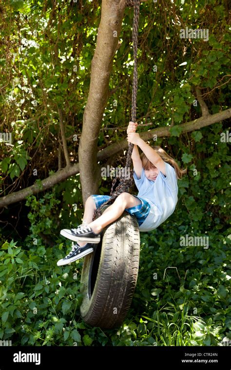 A Little Girl Swinging From A Tire Swing Stock Photo Alamy
