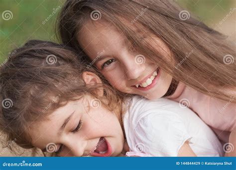 Portrait De Deux Petites Filles Heureuses Riant Et étreignant Au Parc D