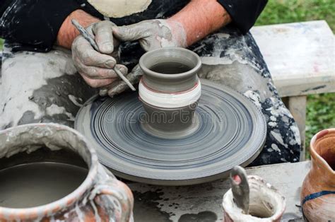 Close Up Of Hands Making Pottery From Clay On A Wheel Stock Photo