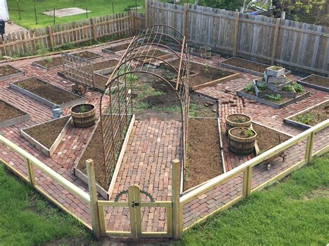 Brick Paths In The Garden Of Raised Beds With A Homemade Arch For