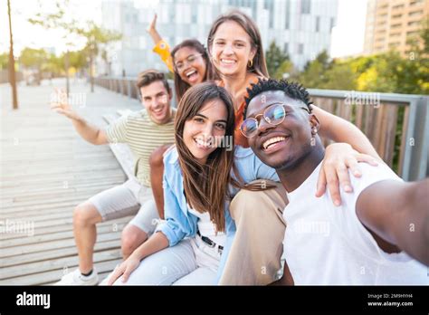 Happy Multiracial Group Of Friends Making A Selfie With Phone In The University Focus On The