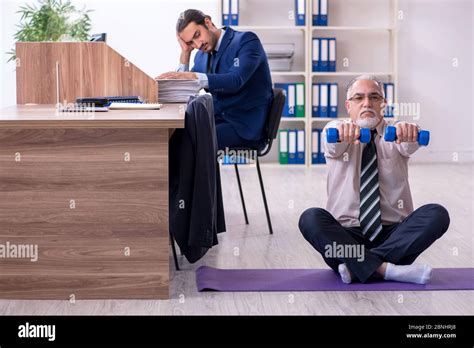 Two Employees Doing Physical Exercises At The Workplace Stock Photo Alamy
