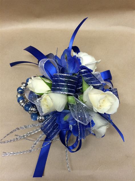 A Wrist Corsage Featuring White Roses And Blue Delphinium Prom