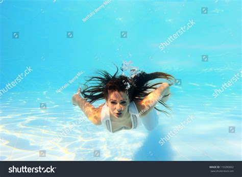 Woman Wearing A White Dress Underwater In Swimming Pool Stock Photo