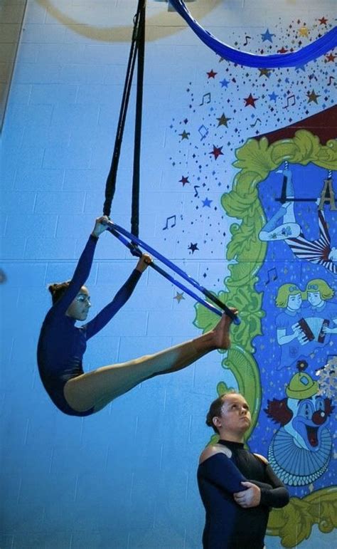 Two Acrobats Performing Aerial Tricks In Front Of A Mural