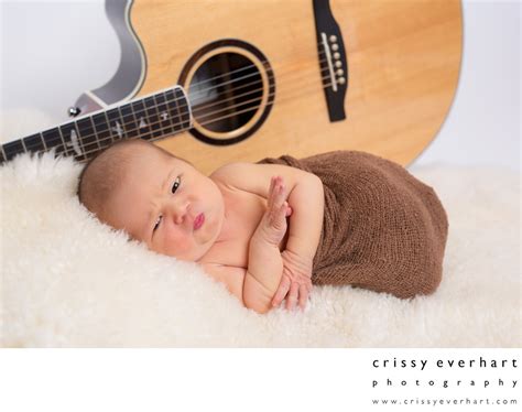 Newborn Photography Baby In Front Of Dads Guitar