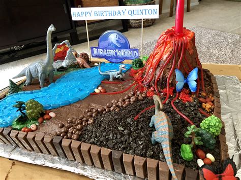 A Birthday Cake Decorated With Dinosaurs And Other Things In The Shape