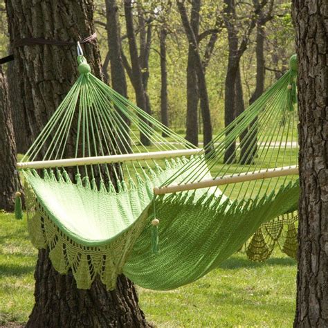 A Lovely Crocheted Hammock In Light Spring Green Suspended Between Two