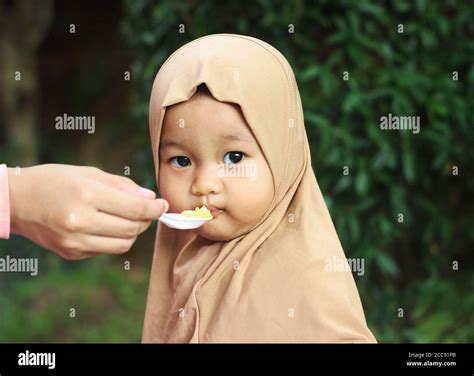 A Cute Beautiful Muslim Indonesian Baby Girl Being Fed By Her Mother