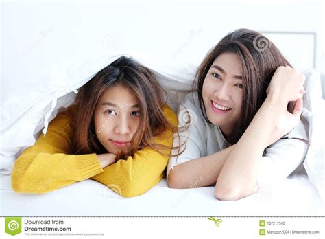 Lgbt Young Cute Asia Lesbians Lying And Smiling On White Bed To Stock