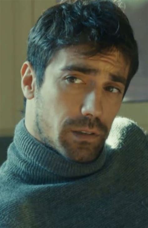A Man Wearing A Turtle Neck Sweater Looking At The Camera