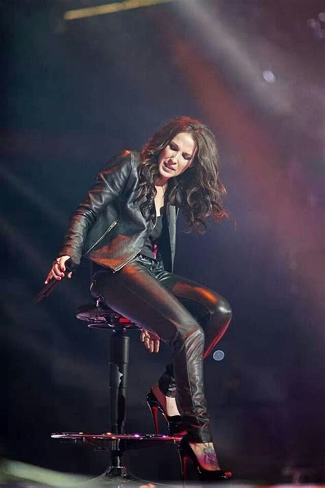 A Woman Sitting On Top Of A Stool With Her Legs Spread Out And Wearing