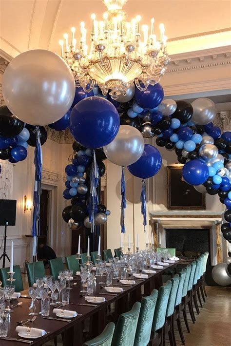 A Long Table With Blue And White Balloons On It Along With Place