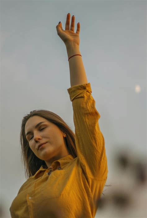 A Woman In Yellow Dress Shirt Raising Her Arm · Free Stock Photo