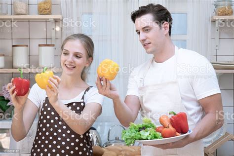 Couples Having Fun Together While Cooking In The Kitchen Eating Good