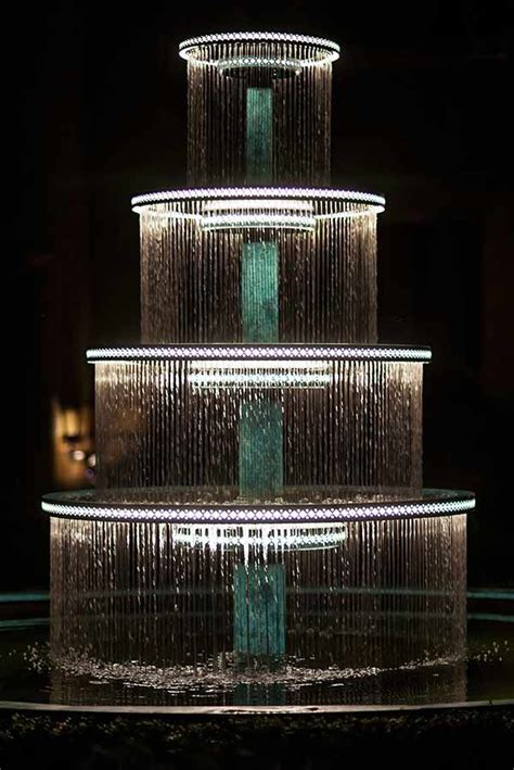 A Water Fountain Is Lit Up In The Dark
