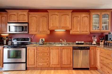 I'm not going to ask you to change the flooring, but we can minimize the oak overload by adding a runner in the kitchen and an area rug under the eat in kitchen table. Red Kitchen Walls With Oak Cabinets | online information