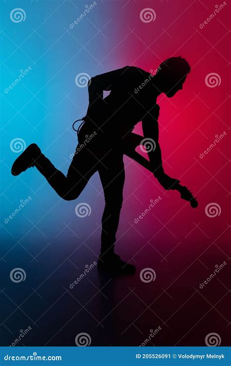 Silhouette Of Young Caucasian Male Guitarist Isolated On Blue Pink