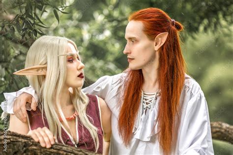 an elf man and an elf woman are standing near a tree a pair of stunning detailed elven