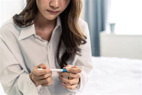 Close Up Of Woman Feeling Shock After Look At Positive Pregnancy Test